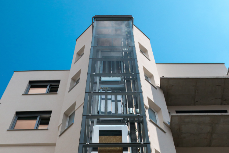 Atypický prosklený výtah na boku budovy