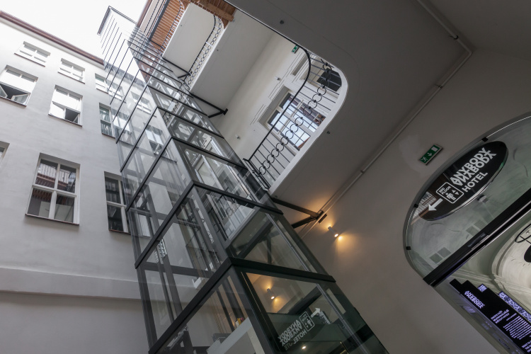 Presklený panoramatický výťah vo vnútornej časti bloku budov