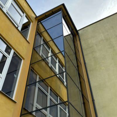 Moderní prosklený osobní výtah umístěný mimo budovu